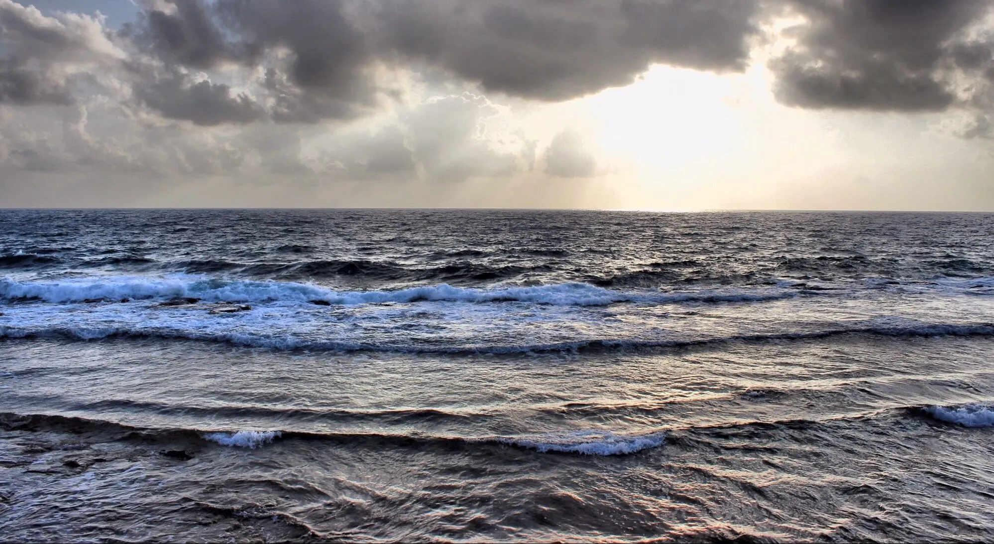 Golven op zee onder een wolkenlucht